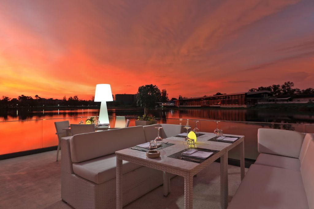Lakeside dining table at sunset at Bocconcino Phuket