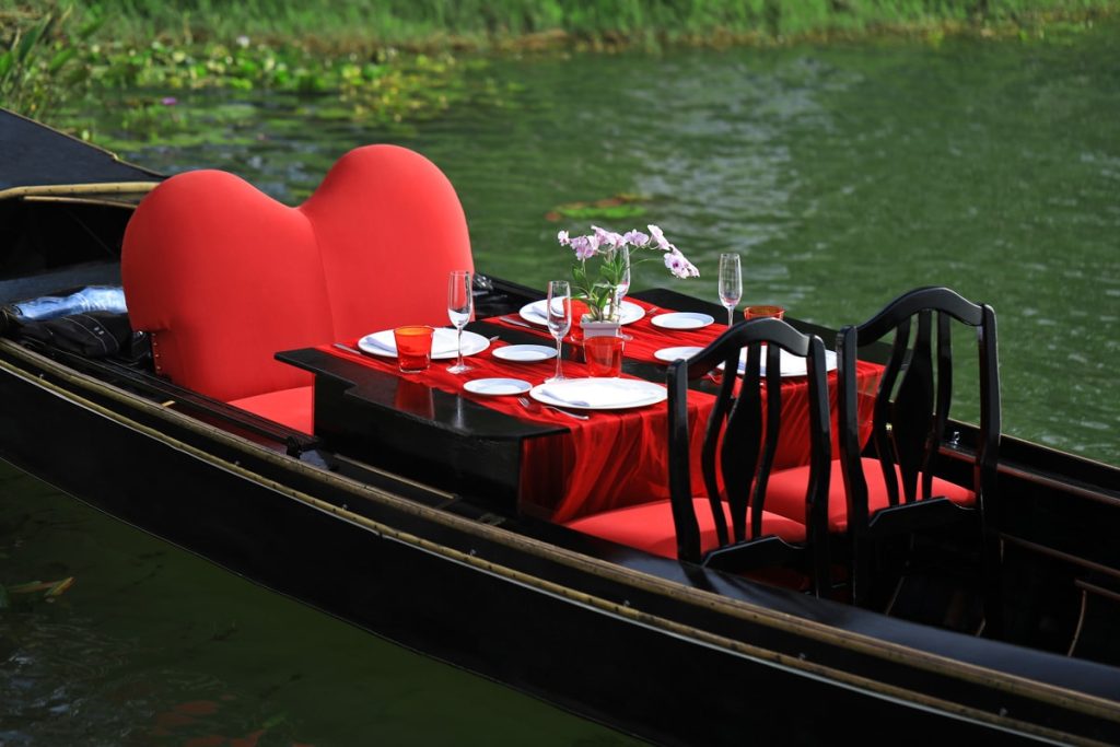 Romantic dinner table set inside a gondola on the lake