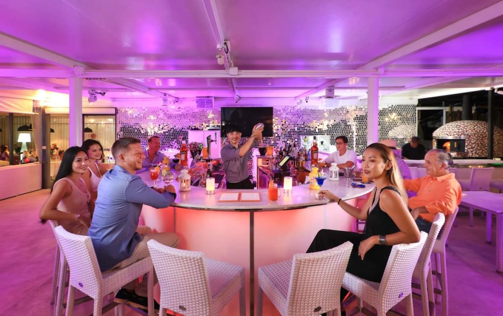 Guests enjoying drinks at the terrace bar in the evening