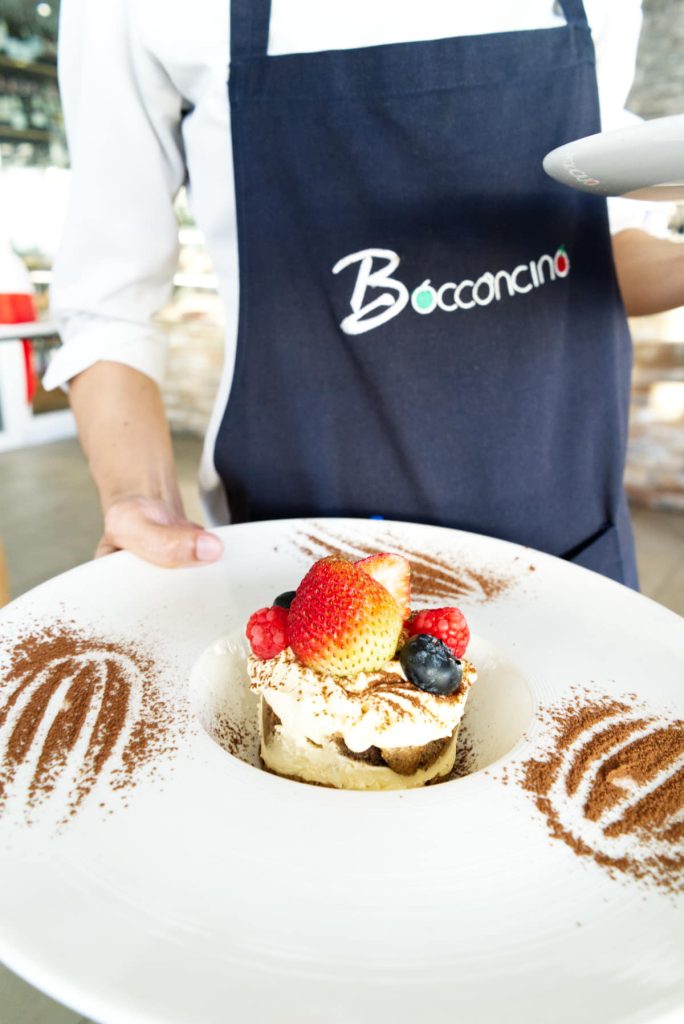 Waiter serving a dessert at Bocconcino
