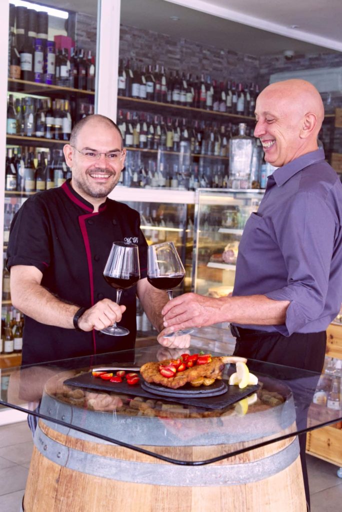 Alessandro Pegoraro and Massimo Pettinau toasting with wine at Bocconcino