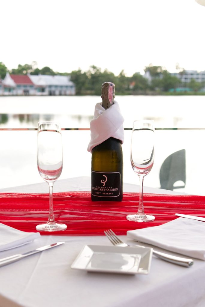 Bottle of wine on a table set by the lake